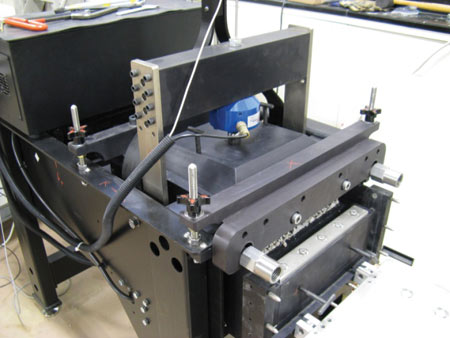 Figure 1. Photo. Large-scale DS device at TFHRC. The photo shows a large-scale direct shear device that has been set up for testing. Some of the open-graded aggregate sample in the bottom shear box, which moves relative to the top shear box, is visible in the picture.