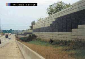 photo:  metal panel noise barrier, viewed from the highway side, with a varied-color geometric design on the face of the barrier (photo is intended to illustrate a typical example of a barrier designed and constructed to enhance the motorists= view of a barrier)