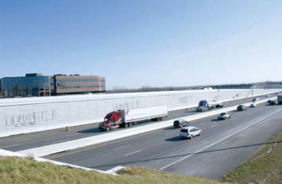 Photo of traffic travelling on I-75, parallel to the wall commemorating the Wright Brothers' historic flight.
