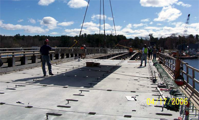This is a photo showing the installation of a precast concrete full depth deck panel.