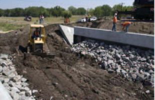 Rip-rap was placed concurrently with the flowfill and partially buried