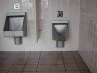 Photo depicting: The lower urinal is installed too low to the floor of the restroom.