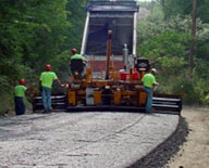 road crew applying driving surface aggregate