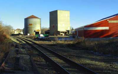Photo: Rails running past industrial buildings