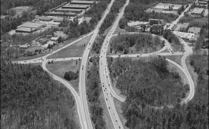 Cameo: An aerial photograph of a modified six-ramp partial cloverleaf (" parclo ") interchange.