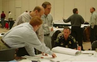 Four men around a table discussing a project