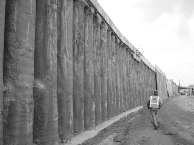 A worker walks along side a drilled shaft wall.
