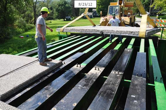 Figure 15. Photo. Place panels on top of prefabricated haunches. Note studs that make a fixed connection between the deck and stringers at midspan.