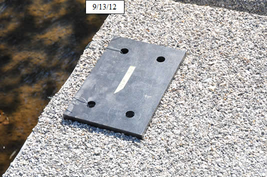 igure 30. Photo. Align prefabricated high-density polyethylene pad for bridge railing posts.
