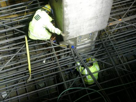 This photo shows the field placement of a precast column into the pre-tied footing reinforcement cage for a bridge in Washington state.