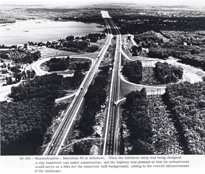 Massachusetts - Interstate 95 in Attleboro.  When the Attleboro strip was being designed, a city reservoir was under construction, and the highway was planned so that its embankment would serve as a dike for the reservoir (left background), adding to the overall attractiveness of the landscape.
