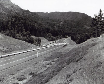Interstate Route I-84 travels rough country along the Columbia River near Cascade Locks, Oregon. A narrow median with safety guard rail was used, since a broad median would have been too costly.