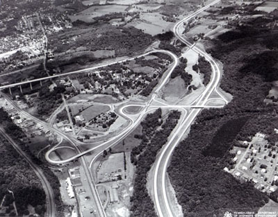 North of Scranton, Pa. Triple trumpet interchanges link Interstate Route 81, on the right side of the picture, U.S. Routes 6 and 11, at the lower left, and the northern terminus of the Northeast Extension of the Pennsylvania Turnpike, which comes in form the left on a high viaduct. Paralleling US 6 and 11 at the lower left is a railroad.