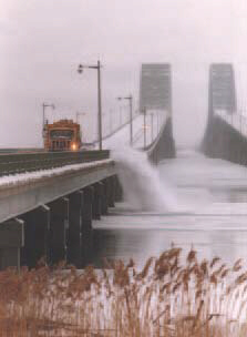 Page 11 Photograph: Picture of a yellow snowplow pushing snow from a bridge deck over the bridge railing