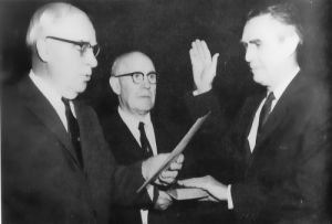 On February 10, 1961, Secretary of Commerce Luther H. Hodges (left) administers the oath of office to Rex Whitton (right) as he becomes the third Federal Highway Administrator.  Carlton Hayward, Director of Personnel Management for the Commerce Department, is the middle man.