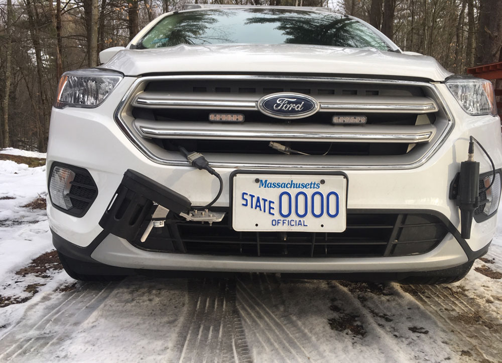 Front of white Ford vehicle with Massachusetts plates.