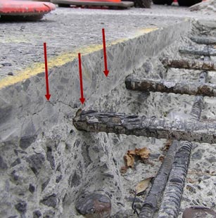 The second image, located to the right of the previous image, shows delamination of the concrete deck. Three red arrows point down to areas of delamination. Five exposed rebars are also seen in the image. 