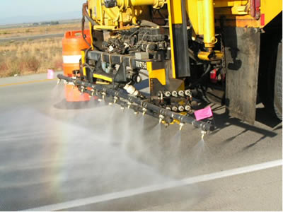 Figure A4b.F2 Photo. Spraying 30-percent lithium nitrate solution with a tanker truck on a concrete pavement near Mountain Home, Idaho. This photo shows a closeup view of a water truck spraying lithium nitrate on an A S R-affected pavement near Mountain Home, Idaho.