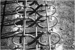 Image of X-Flex™ load transfer devices. Four loops in the shape of a figure 8 resting on its side appear at right angles to three tie bars, two above the loops and one below. The two sides of each figure eight appear to be tied to the tie bars above, and the “X” portion appears centered over and near the third tie bar, below.