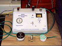 Figure 2. Photo. The Pneumatic Adhesion Tensile Testing Instrument (PATTI) is shown. The PATTI device includes test equipment such as piston, thread plate, air supply hoses, rubber gasket, loading fixture, asphalt sample, and glass substrate. Figure 2. Photo. The Pneumatic Adhesion Tensile Testing Instrument (PATTI) is shown. The PATTI device includes test equipment such as piston, thread plate, air supply hoses, rubber gasket, loading fixture, asphalt sample, and glass substrate.
