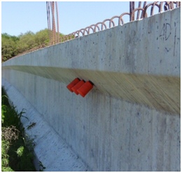 This figure is a photograph of a precast concrete girder with humidity probes inserted and encapsulated in orange plastic protective containers.