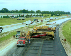 highway construction equipment operating alongside existing highway lanes