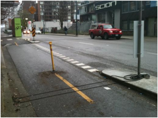 Example of Pneumatic Tube Configuration for Counting Directional Bicyclist Traffic. This photo shows two pneumatic tubes placed across the entire length of an exclusive bicycle facility adjacent to a roadway.