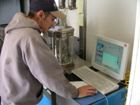 Photo: Worker using the Superpave Performance Tester program on a computer in the mobile asphalt lab.