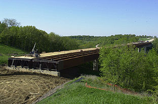 The Iowa River Bridge in Hardin County, IA, was assembled on one side of the river and rolled 496 m (1,630 ft) across the river valley into position.