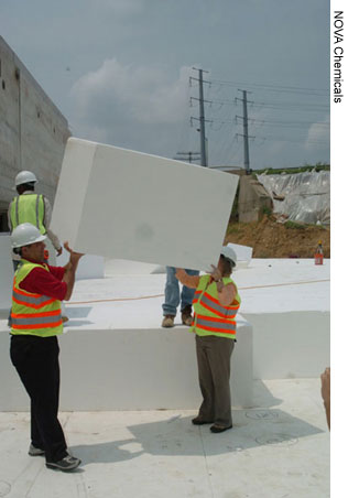 Rudy Maruri (left) of FHWA's Virginia Division Office and Joyce Curtis of the FHWA Resource Center demonstrate the lightness of EPS Geofoam blocks at the July 2006 showcase at the Woodrow Wilson Bridge in Alexandria, VA.