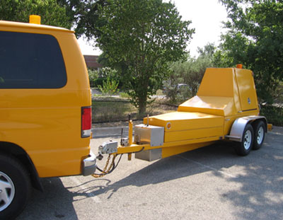 A photo of falling weight deflectometers (FWDs) being pulled by a van.