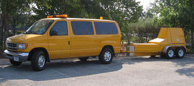 A photo of falling weight deflectometers (FWDs) being pulled by a van.