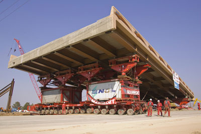Figure 1. Photo. A self-propelled modular transporter moves the prefabricated superstructure of the new 4500 South bridge in Salt Lake City, Utah.