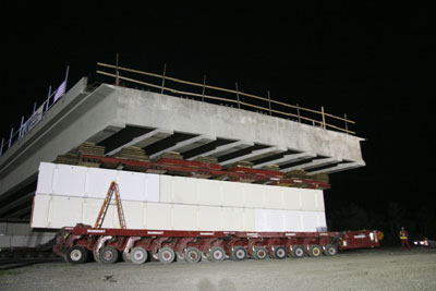 Figure 6. Photo. The new Graves Avenue bridge is loaded on a self-propelled modular transporter.