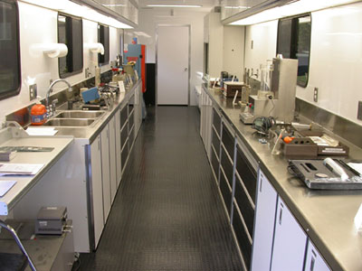 Figure 7. Photo. Interior of FHWA's Mobile Concrete Laboratory. Counters on each side of the lab hold testing equipment, sinks, and work space.