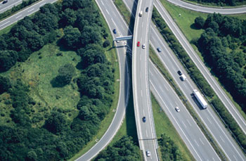 An aerial view of a highway junction with five roads. An elevated highway crosses over four roads underneath.
