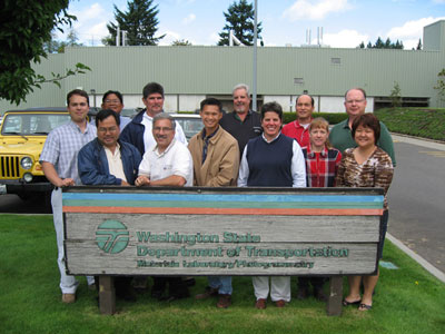 Photo. Hawaii scanning tour team members. The 12 team members stand behind a sign for the Washington State Department of Transportation.