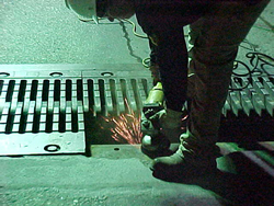 Figure 1. Photo. A worker uses welding tools to prepare the bridge surface for the placement of new finger joints on the Inner Harbor Canal Bridge in New Orleans, LA.