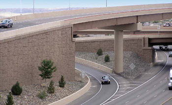  Figure 4. Photo. A view of a highway overpass and road running beneath it. A car is traveling on the road. To the left of the roadway are mechanically stabilized earth walls.
