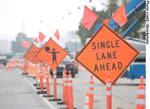Figure 3. Photo. A close-up view of work zone signs warning motorists of a "single lane ahead."
