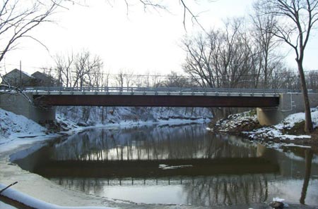 Figure 4. Photo. A winter view of the Tiffin River Bridge in Defiance County, Ohio. The surrounding trees are bare and snow is visible on the river banks. The bridge is one of 23 that Defiance County has built using GRS-IBS.