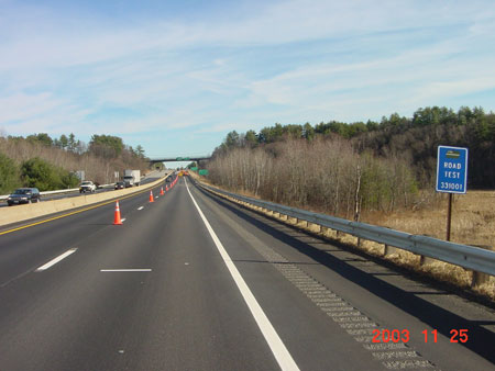 Figure 8. Photo. One of the nearly 2,500 in-service pavement test sections of the Long-Term Pavement Performance program. A sign on the right side of the roadway reads "ROAD TEST 331001." Traffic travels on the other side of the roadway.