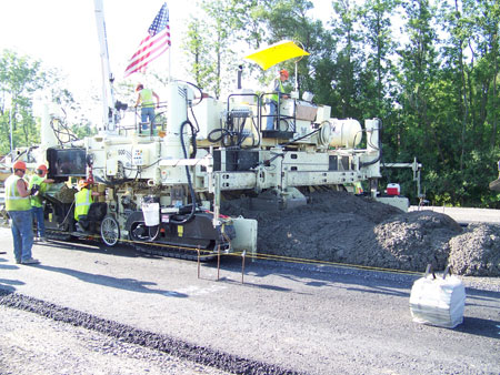 A close-up of paving equipment as long-life concrete pavement is constructed along a section of I-90 near Syracuse, NY.