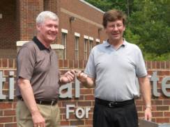 Ray Brown, director of NCAT (left), is shown receiving FWD keys from Brandt Henderson, LTPP regional field data collection and equipment manager (right).