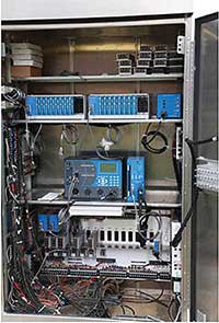 Photo of a signal control cabinet with the doors open showing the wires and equipment for dedicated short range communications.