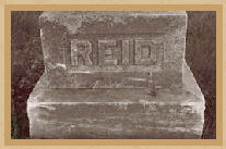This photograph is of an older gravestone.  The name Reid is all that is visible on the stone.