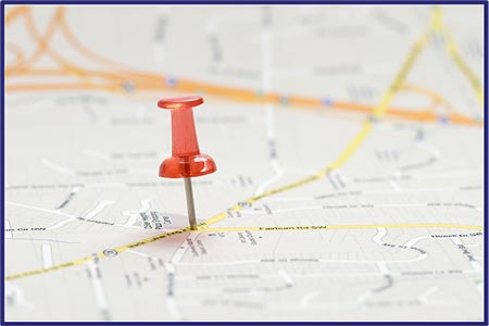 Picture of a map with a push pin at an intersection point of two major roadways. Picture of a map with a push pin at an intersection point of two major roadways.