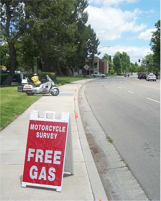 Photo of a sign on a sidewalk offering a free gas incentive to participate in a motorcycle survey Photo of a sign on a sidewalk offering a free gas incentive to participate in a motorcycle survey