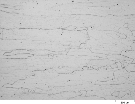 This photomicrograph shows an etched microstructure of a 5Cr2Si2Al steel plate from heat 67-V1-80 in the as-normalized condition zoomed to 50X. It shows elongated white grains with an aspect ratio of about 10 to 1. A scale mark about 15 percent of the length of the photo is marked 7.8 mil (200 microns).
