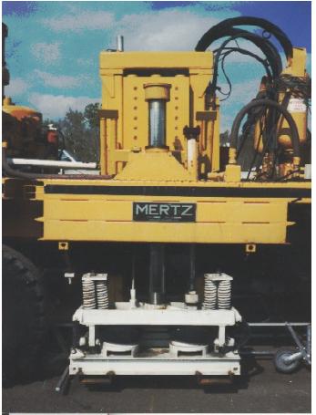 Vertical vibrator mechanism of Vibroseis truck. This image shows the vertical vibrator located directly on the pavement behind the truck. The vibrator is separated from the Vibroseis truck through a system of air springs.